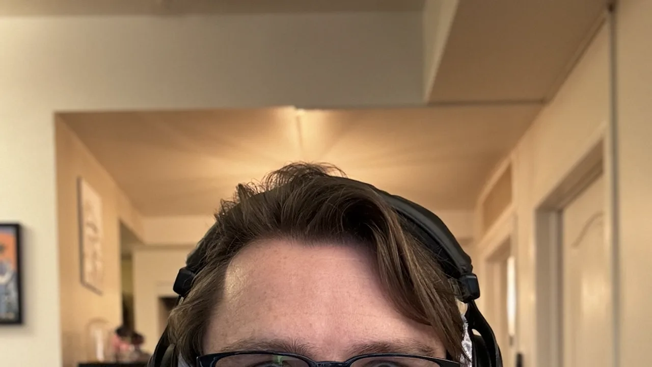 Self portrait wearing headphones at a workstation