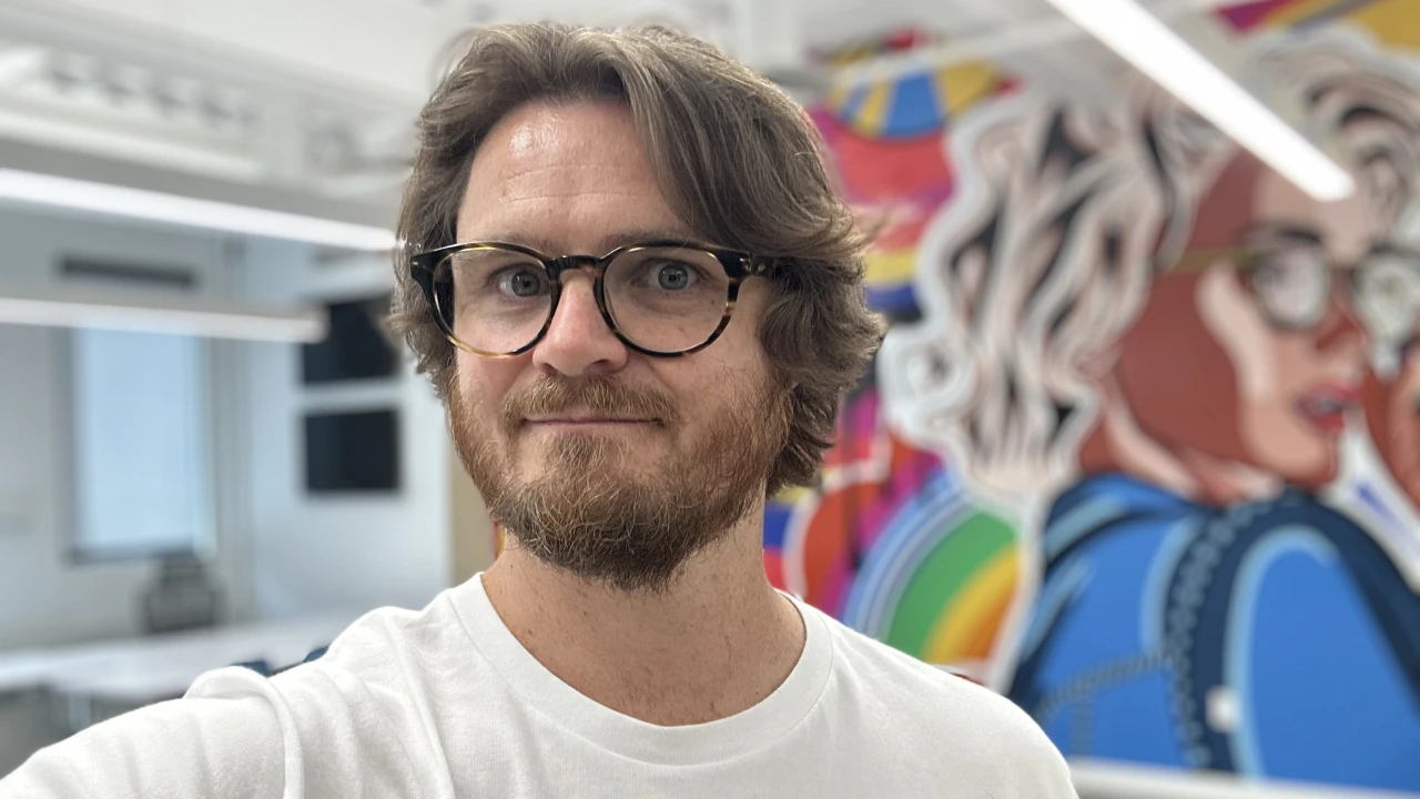 Self portrait beside a colorful studio mural