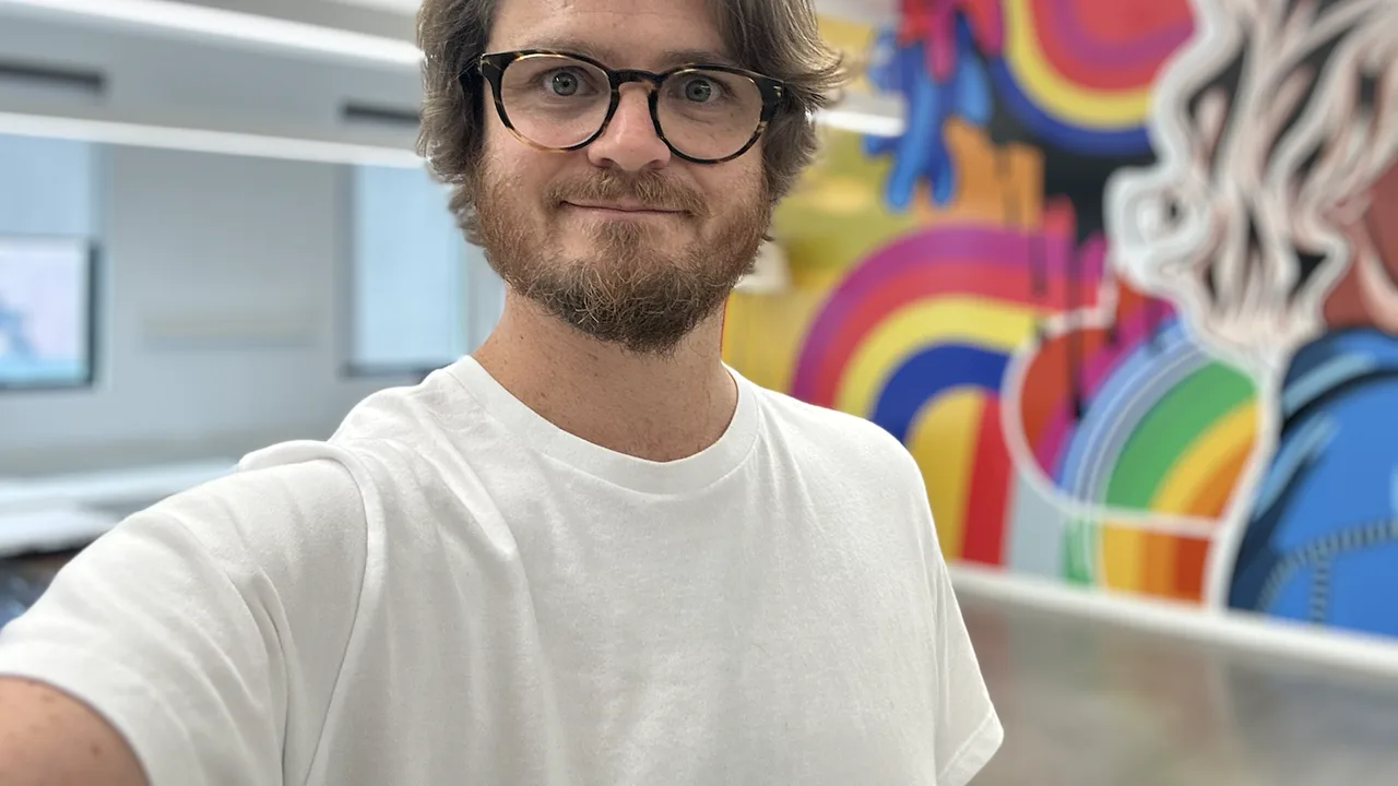 Self portrait beside a colorful studio mural