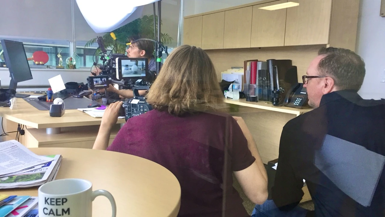 Camera crew filming in an office