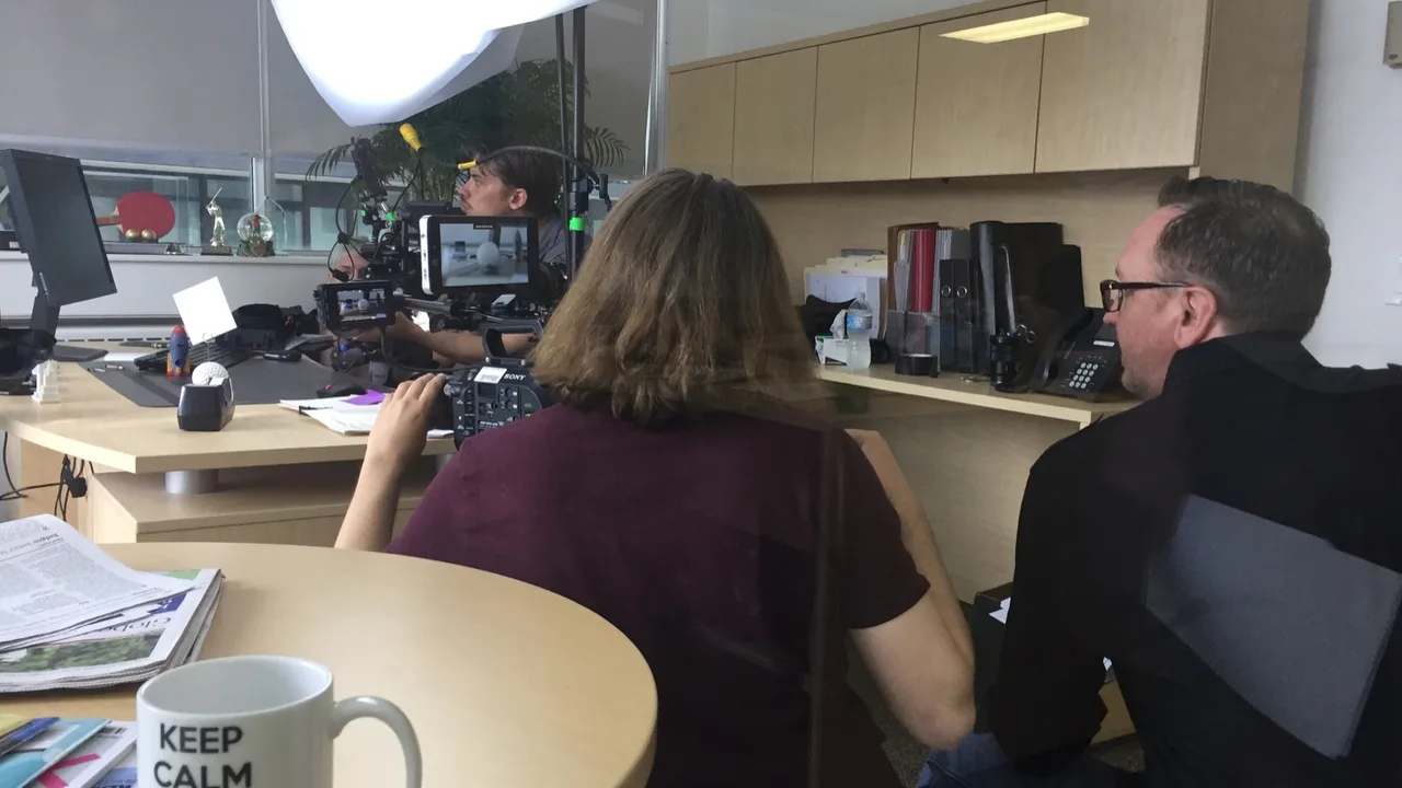 Camera crew filming in an office